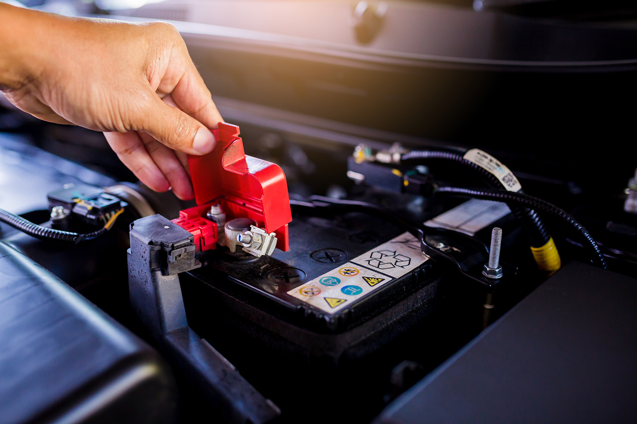 Pulling the cap off a battery terminal, the first step in how to jump a car