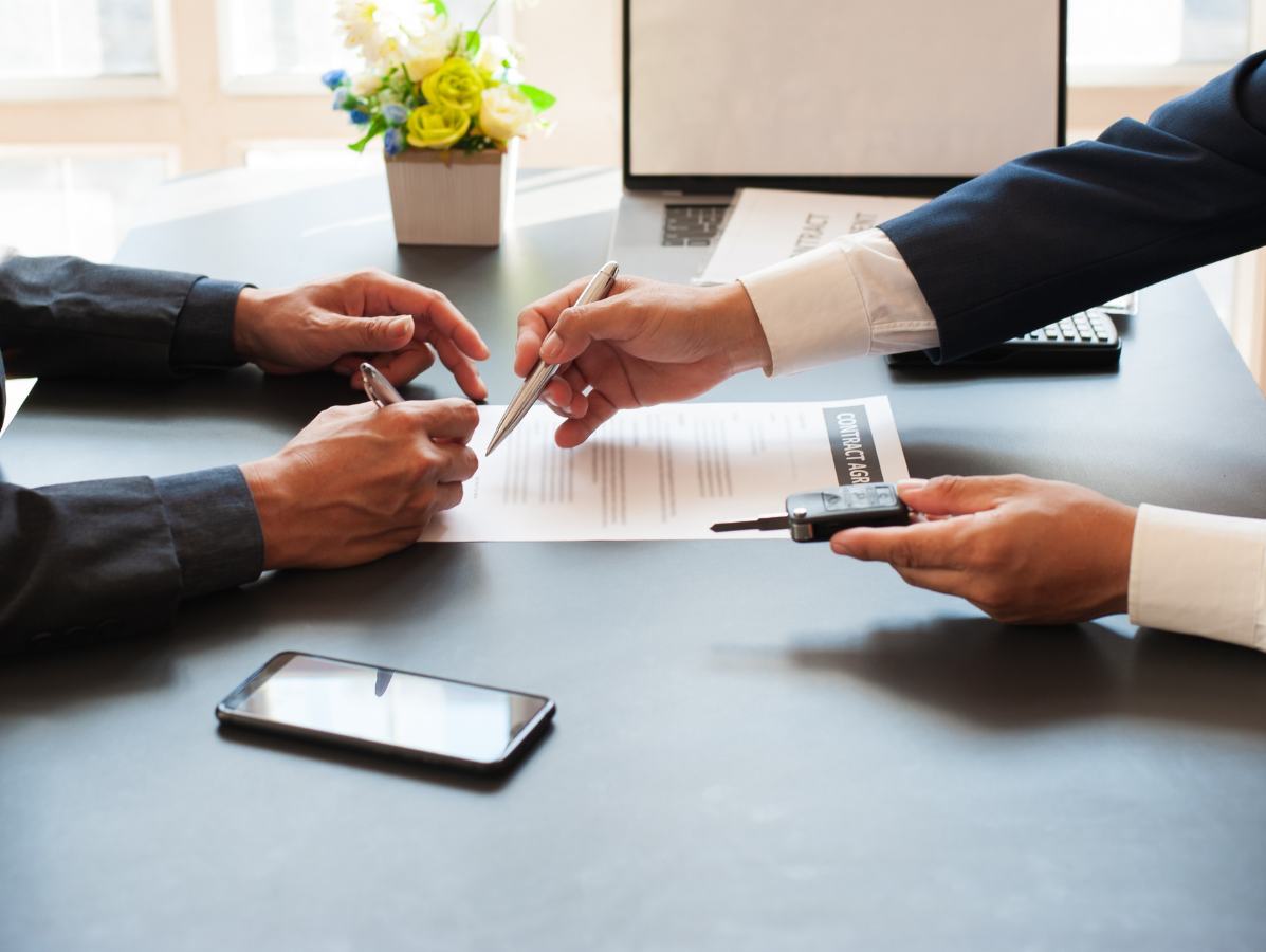 Two people sitting at a desk looking at a contract.