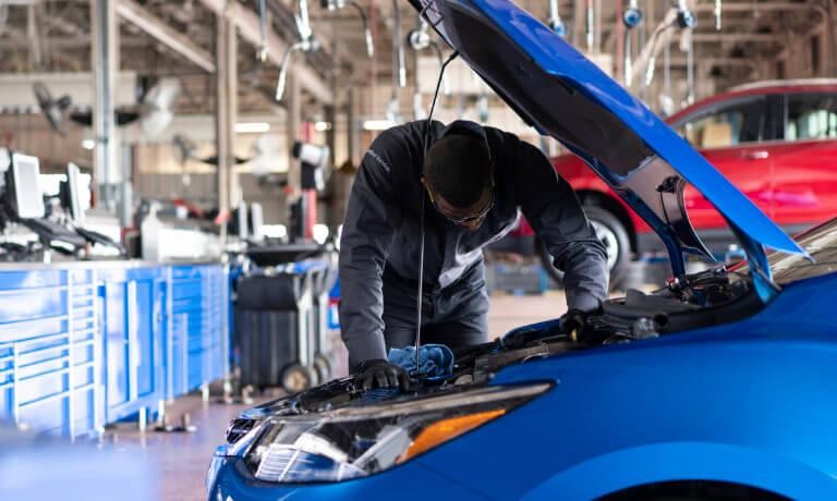 Service Technician inspecting under hood