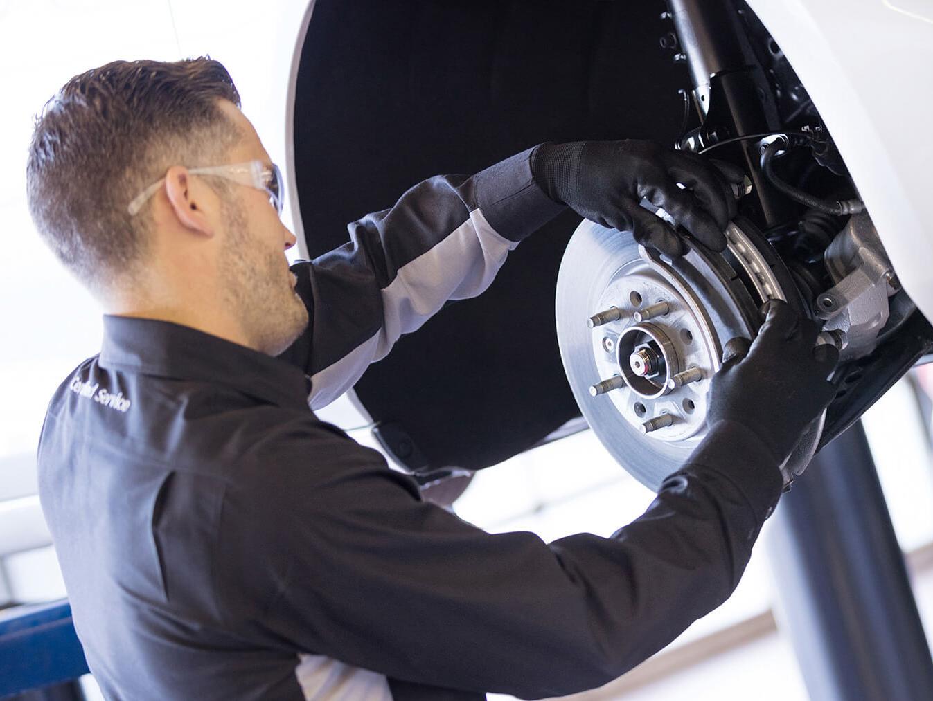 Service technician changing brake pads Service technician changing brake pads