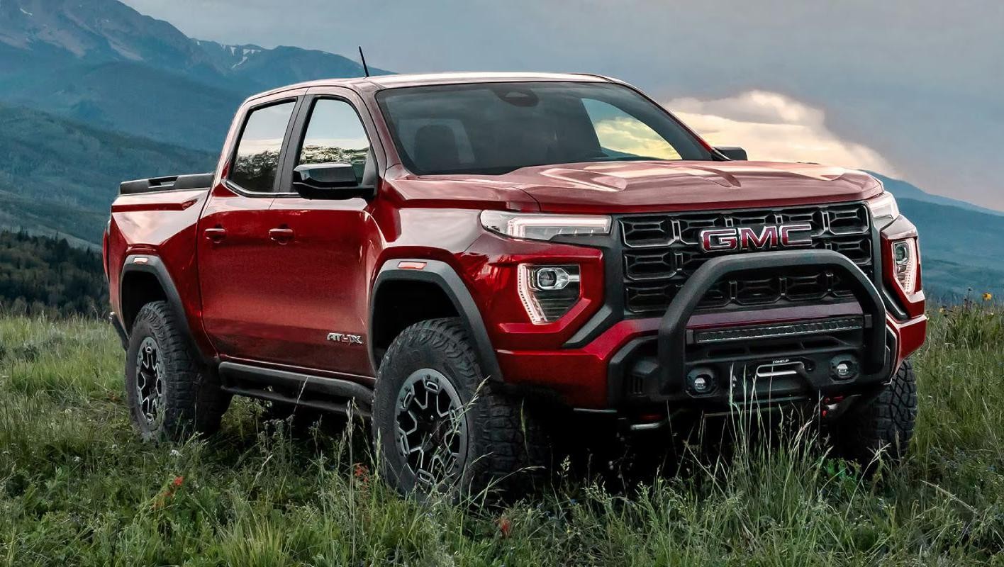 red 2025 GMC Canyon parked in a meadow