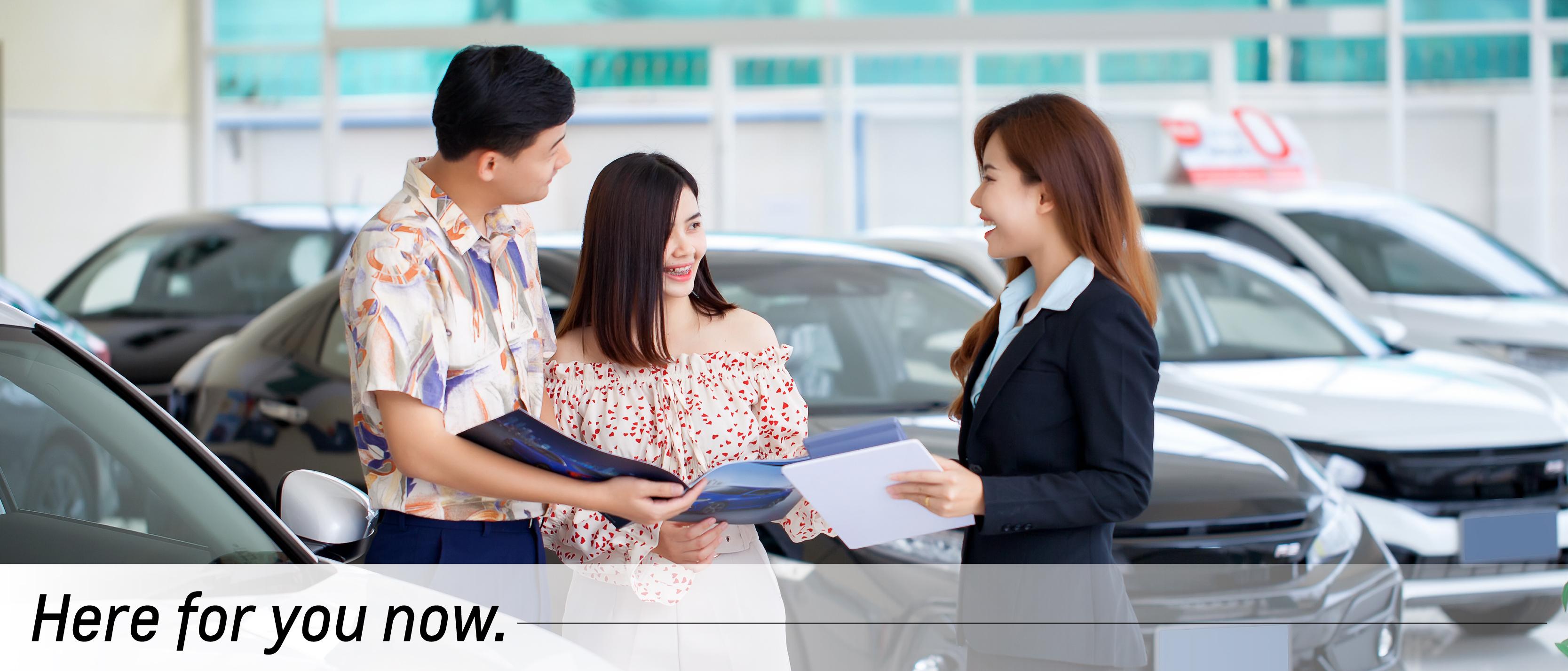 A salesmen shows a woman a vehicle. A salesmen shows a woman a vehicle.