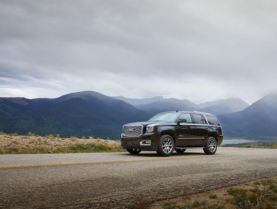 A GMC SUV is parked on the side of the road.