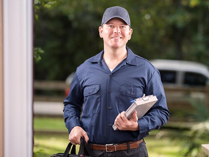 Service mechanic greeting a woman at her door and a mechanic working on a vehicle in a garage