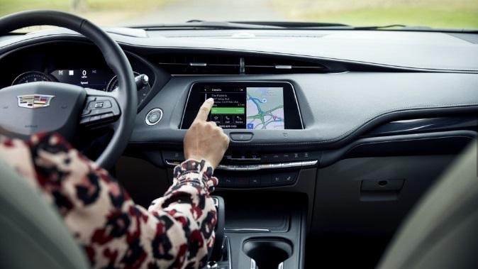 Woman using Cadillac XT4 navigation while driving Woman using Cadillac XT4 navigation while driving