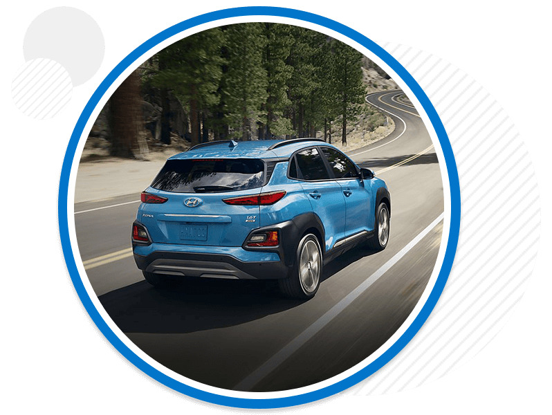 Hyundai vehicle driving down road.