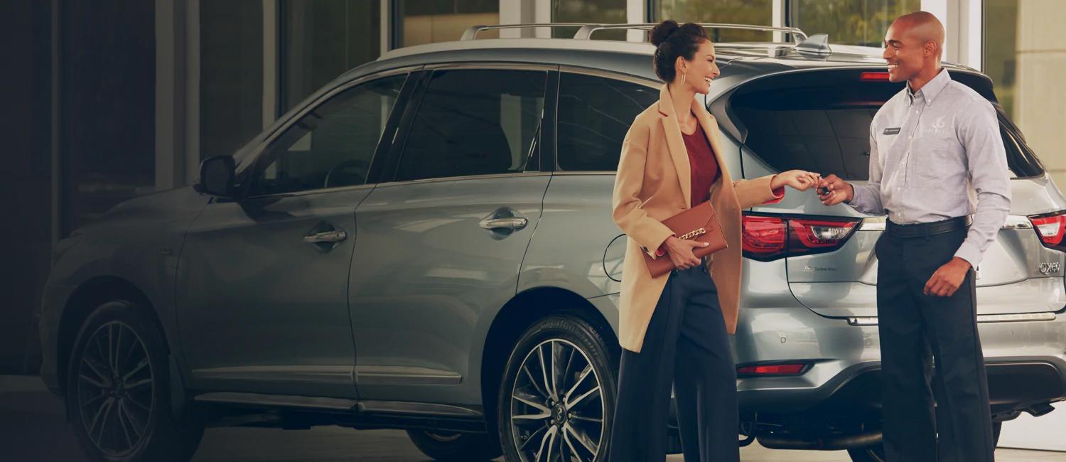 Lady shaking handing with advisor in dealership Lady shaking handing with advisor in dealership