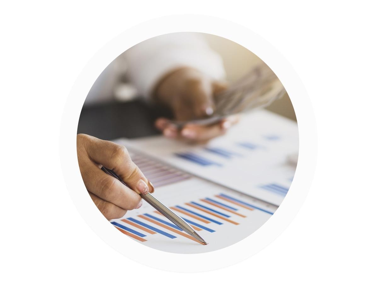 Man pointing to a financial chart holding money