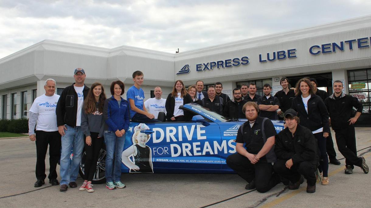 Group of people smiling near a vehicle