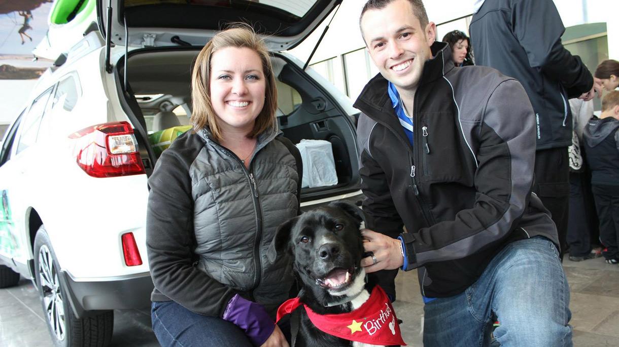 A smiling couple with a dog