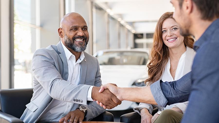 Smiling woman in the showroom enjoying luxury car