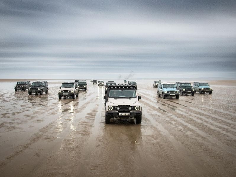 Fleet of INEOS Grenadiers driving on a beach