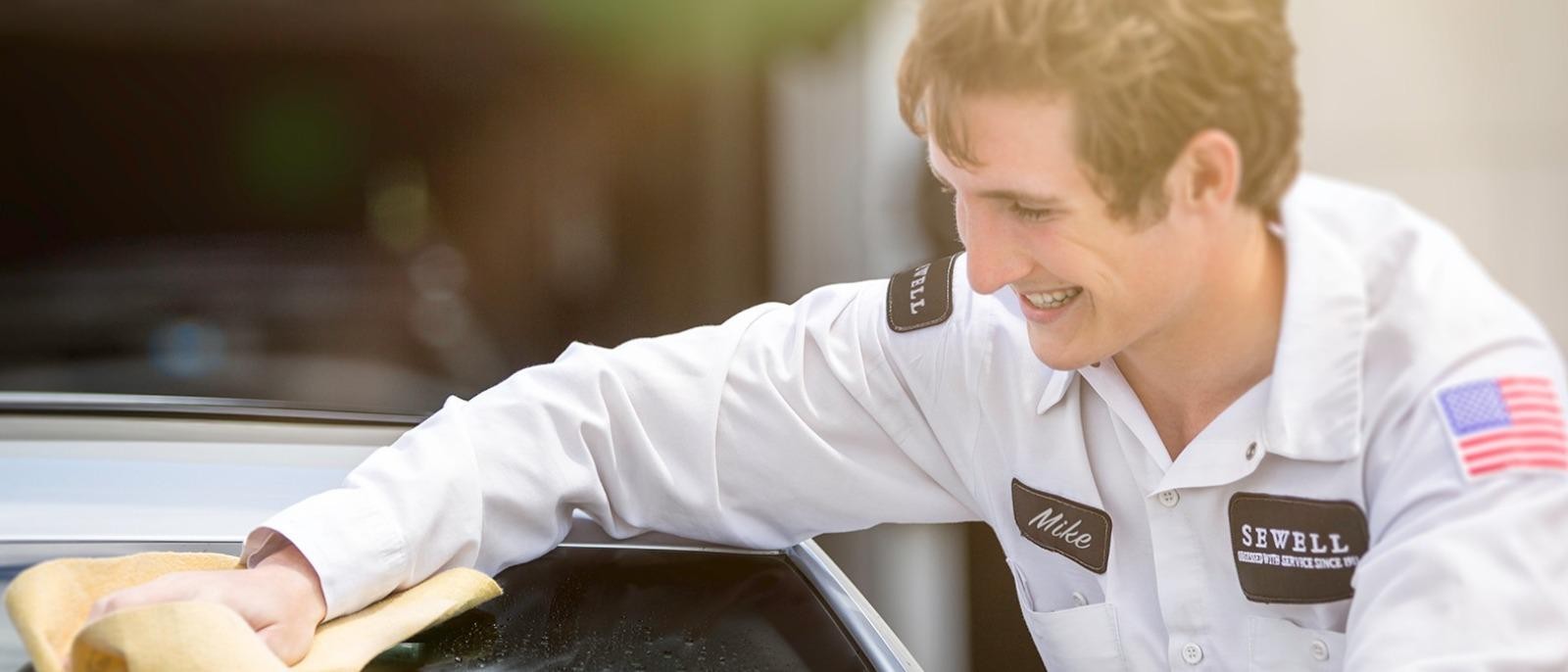 Sewell Associate washing a vehicle for a customer