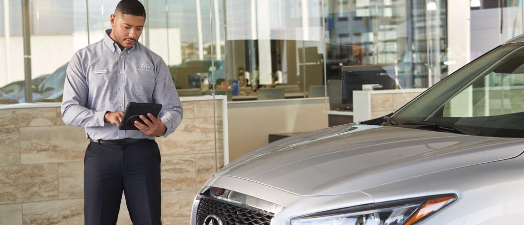 As we return to normal, our customers’ peace of mind is paramount. Image of INFINITI technician making notes.