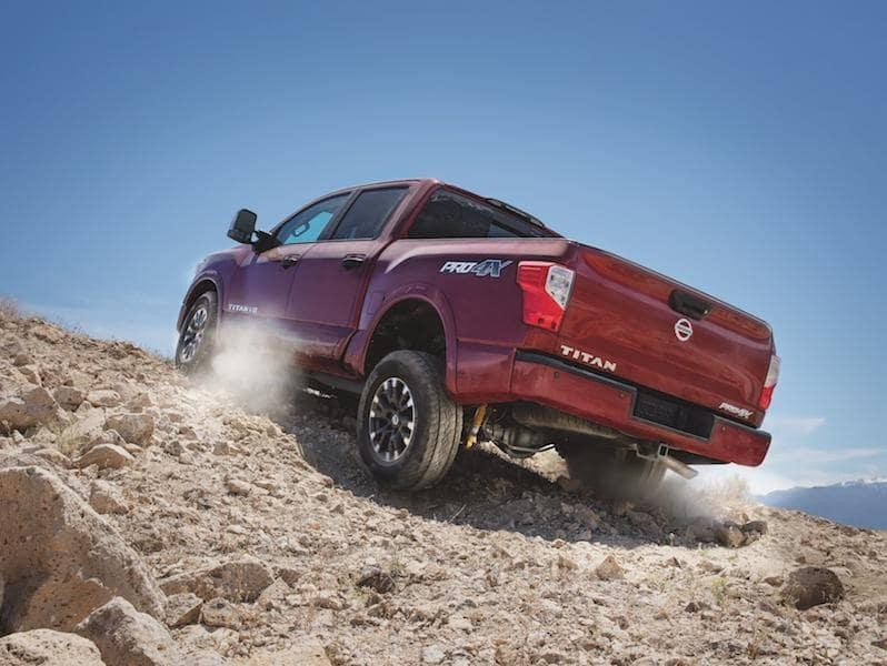 Red Nissan Titan climbing mountain trail