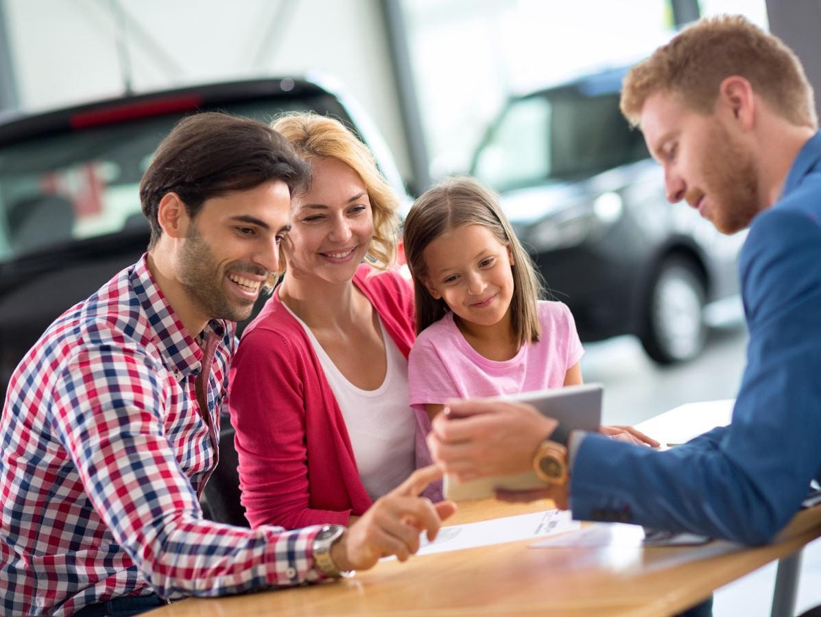 Happy family in car dealership choosing their new vehicle