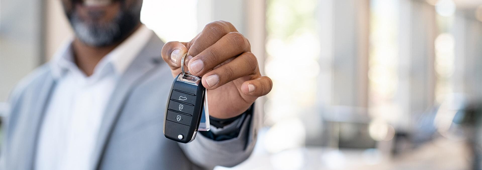 Man holding keys inside dealerships Man holding keys inside dealerships