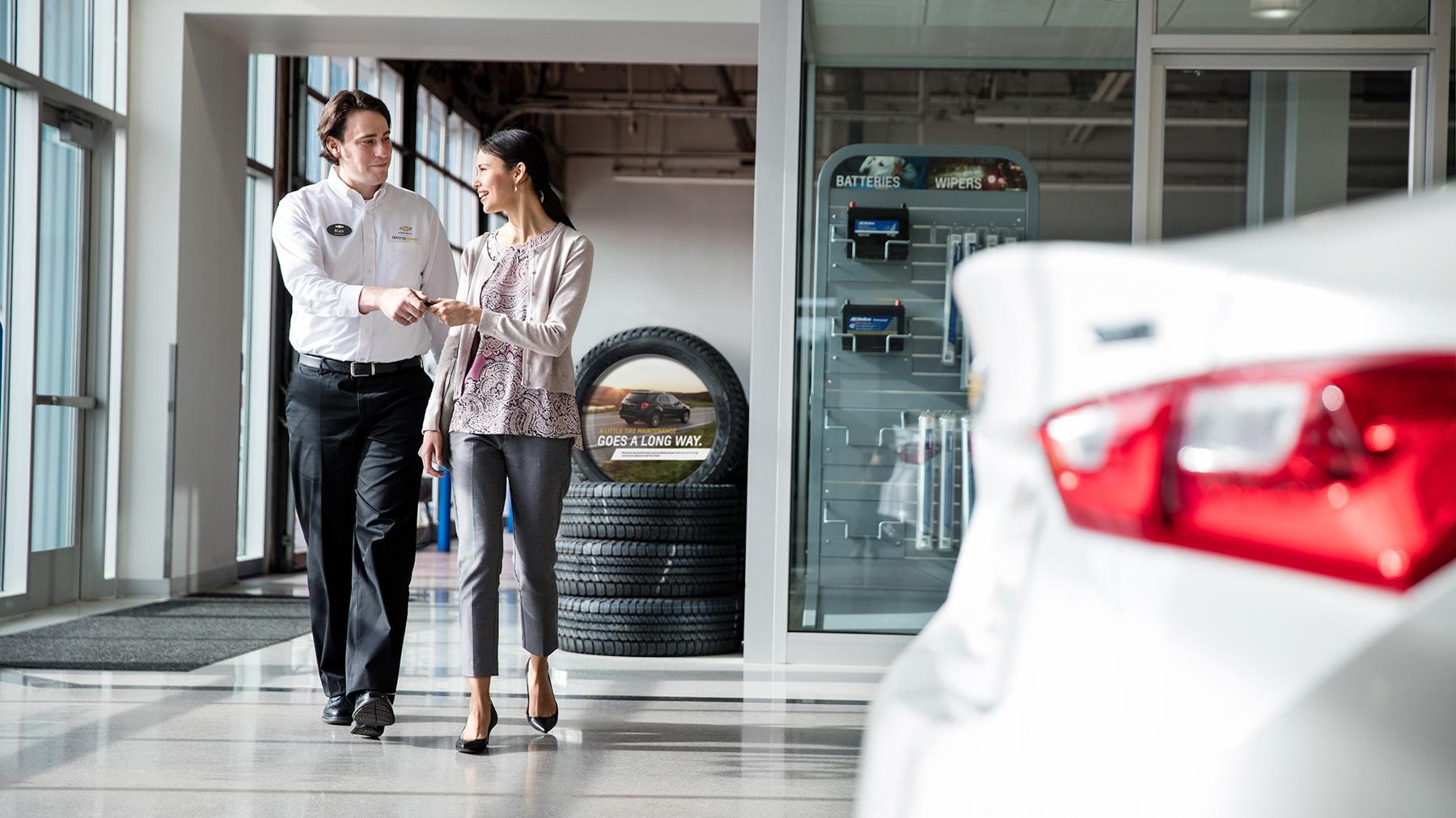 Chevrolet, GMC, Buick Certified Service Employee handing keys to women.