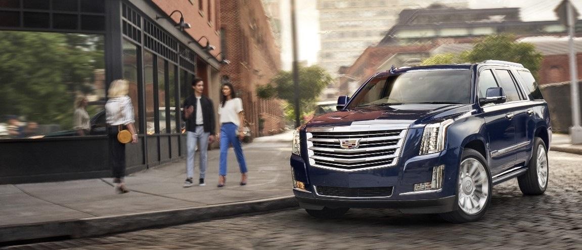 Pedestrians Eying a Blue 2018 Cadillac Escalade as it Rounds City Corner