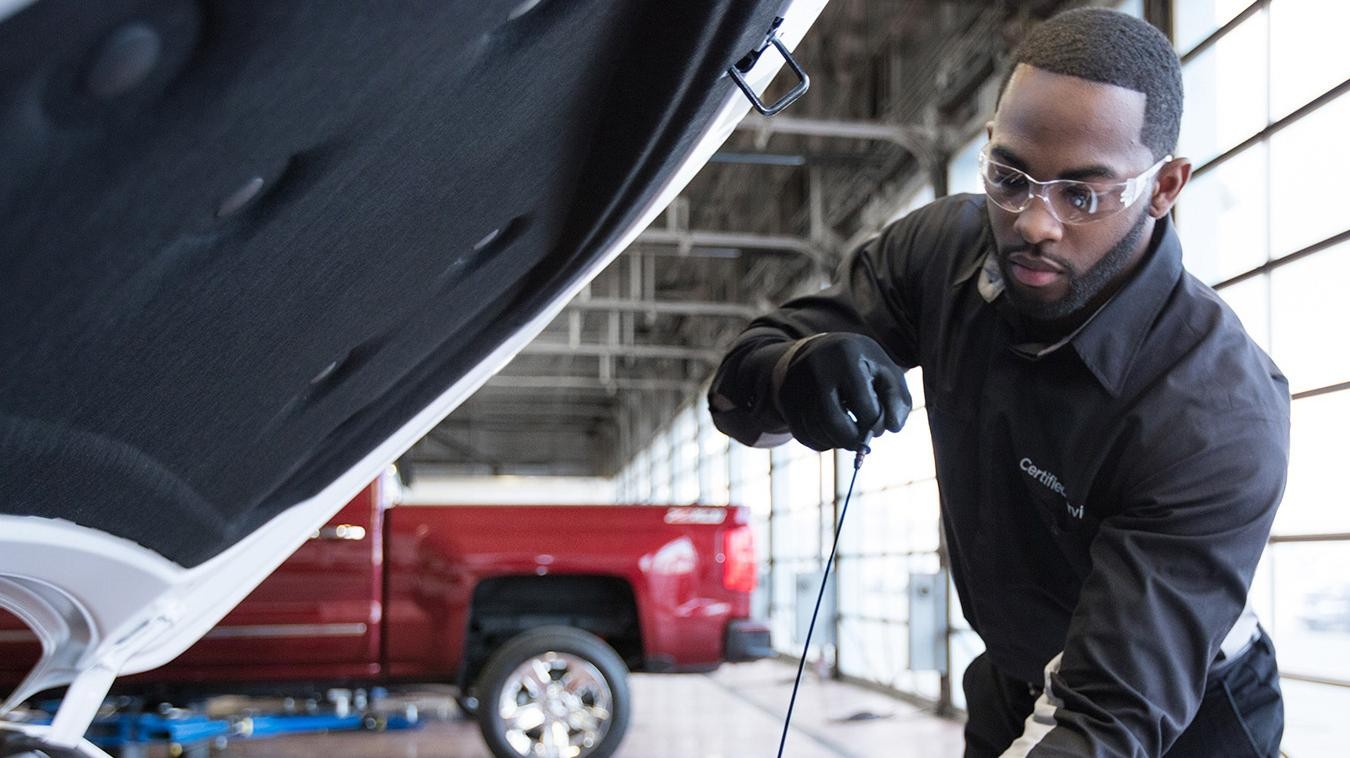 Service technician checking vehicle oil