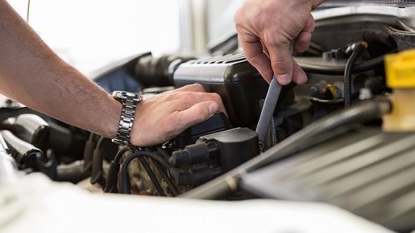 Certified technician servicing Cadillac engine