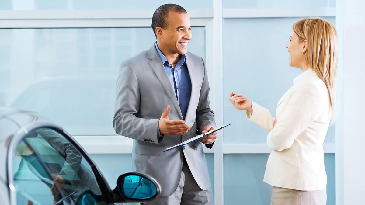 Woman Chatting with Salesperson in Dealership Showroom