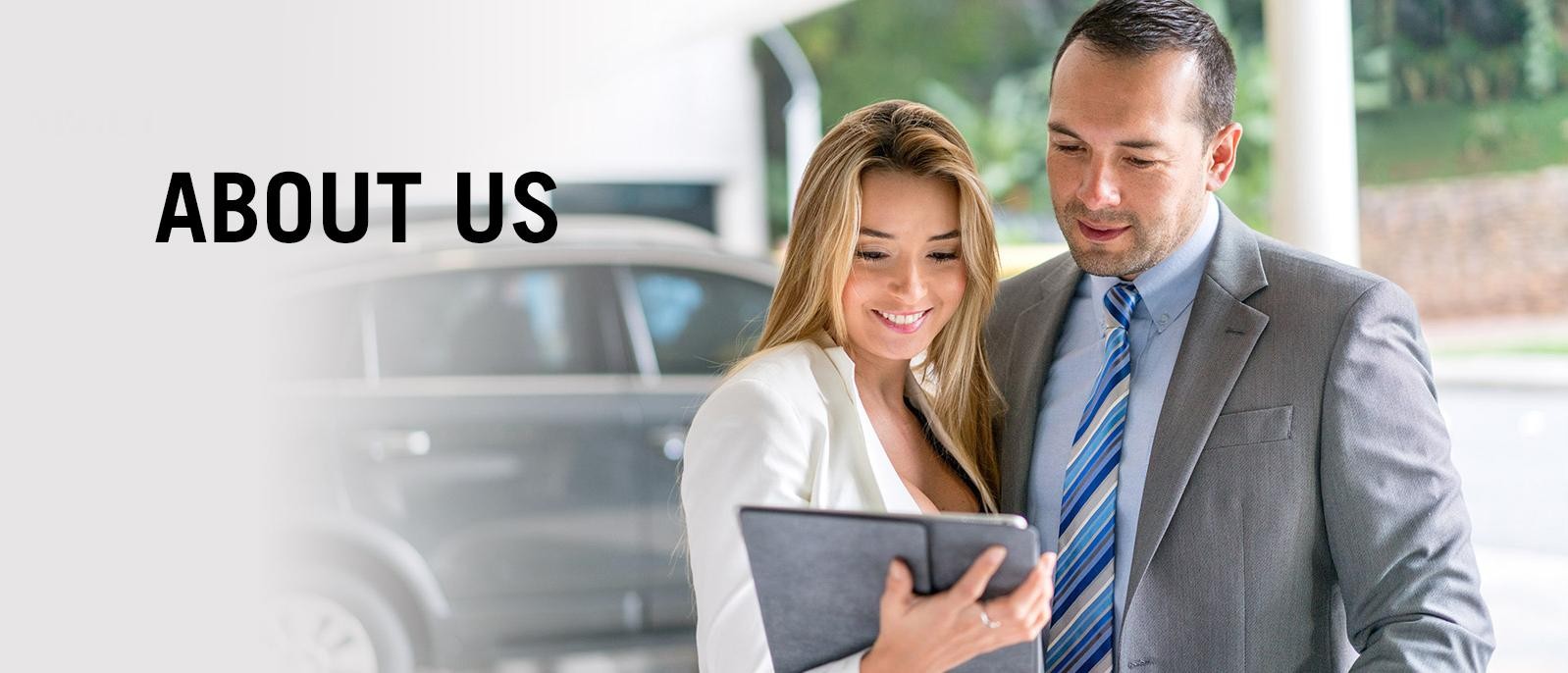 Sales professionals looking at tablet on dealer showroom