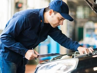 GM Dealer Service Center Employee Inspecting Vehicle with Checklist