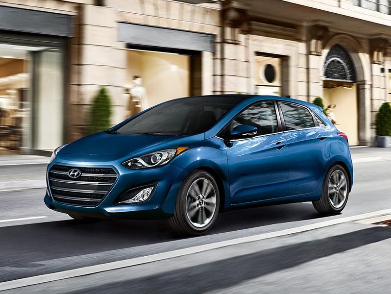 2016 Hyundai Elantra GT cruising down the street along store fronts.
