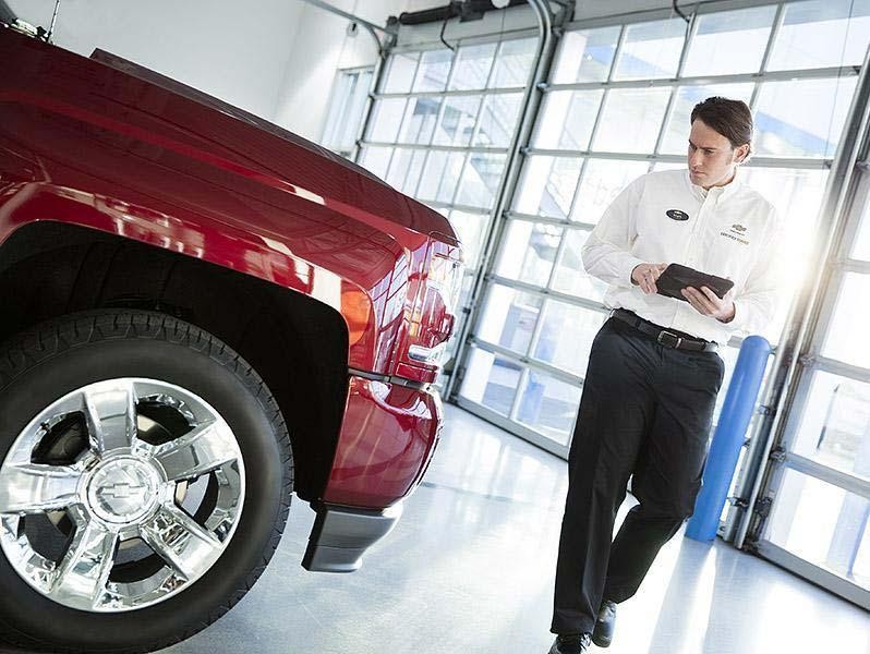 Service technician inspecting vehicle Service technician inspecting vehicle
