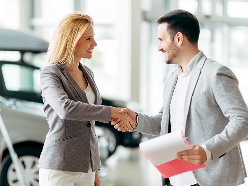 Man closing a car deal with woman.