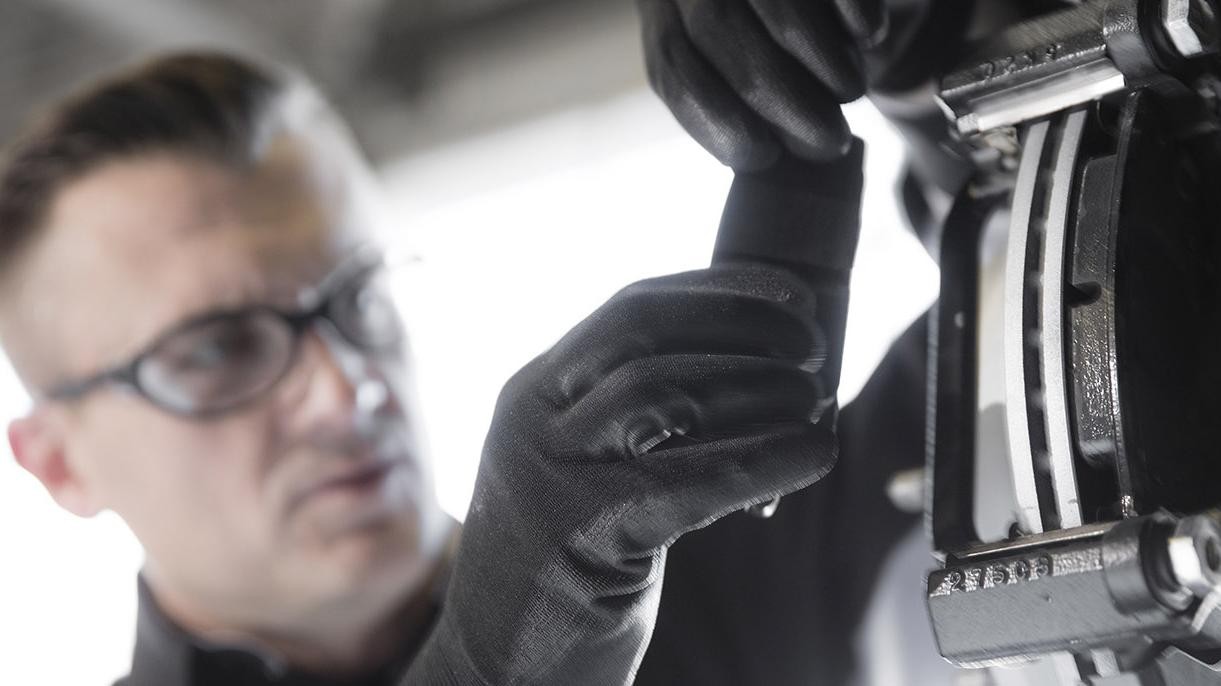 A service technician working on a vehicle's brakes.
