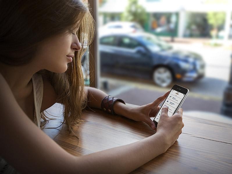 Woman Shopping on Phone with Chevrolet Cruze outside
