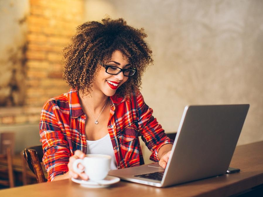 Woman at a cafe looking at her laptop computer.