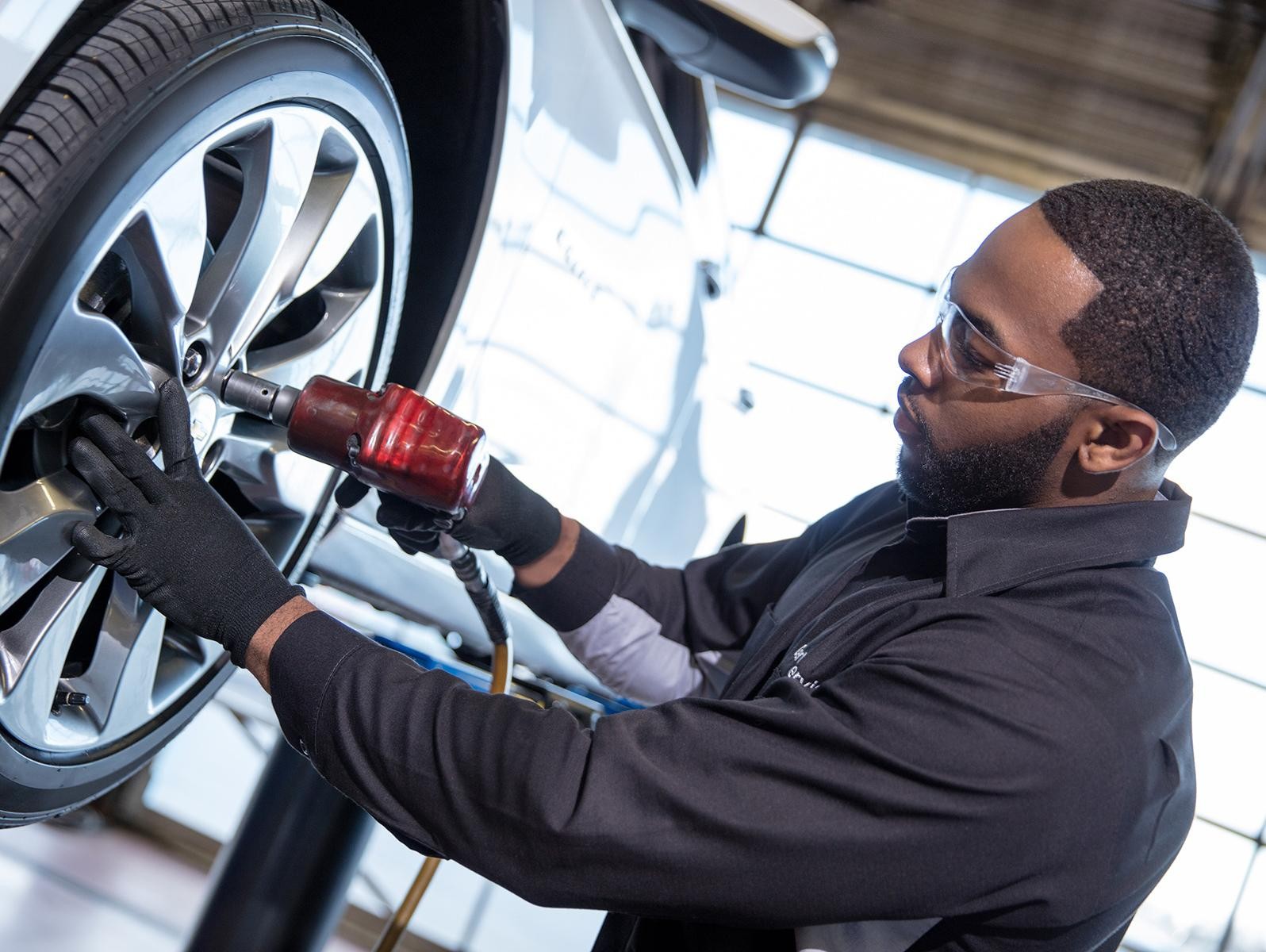 Certified service technician installing a Chevrolet tire