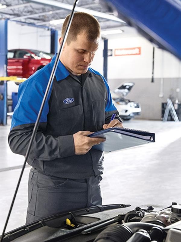 Service technician inspecting Ford vehicle