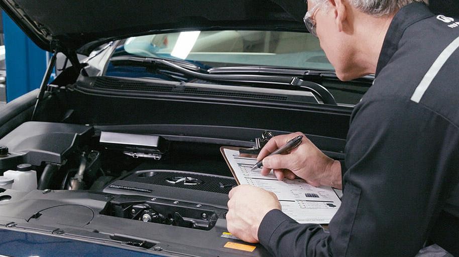 INFINITI Service Technician inspecting vehicle