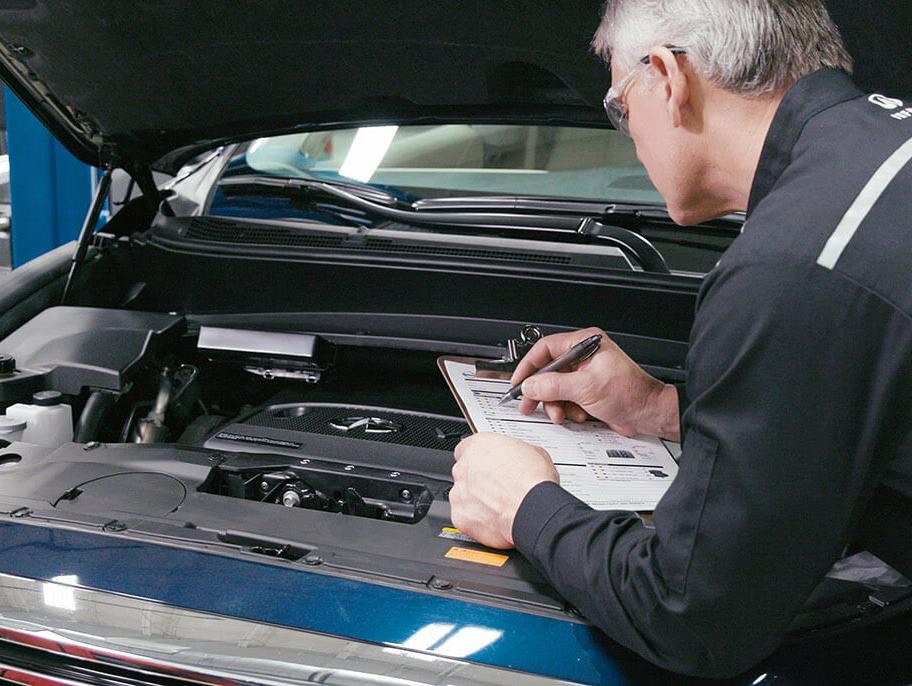 INFINITI Service Technician inspecting vehicle