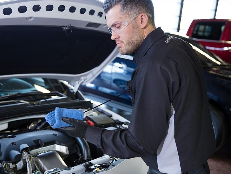 GM technician checking the oil on a vehicle.